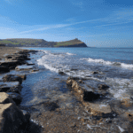 Seaglass hunting on a rocky beach with cliffs in the background, perfect for collecting sea glass an.