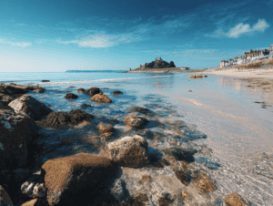 Seaglass hunting on a rocky beach with clear waters and coastal town in the background.